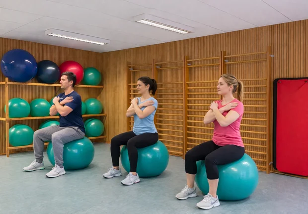Gruppenübung auf Gymnastikbällen in der Physiotherapie – Symbolbild KI-generiert